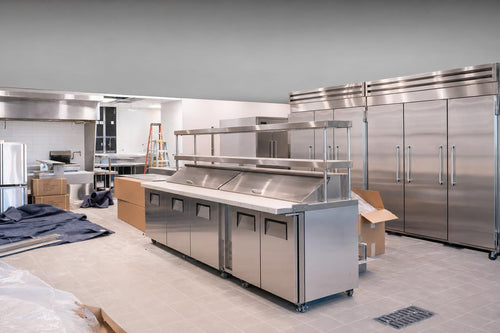 New commercial kitchen equipment being installed during a restaurant remodel