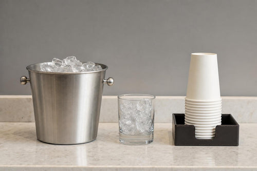 Ice bucket and drinking glass on a clean hospitality counter