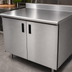 Thumbnail image #3 for Advance Tabco Special Value Series 60-Inch W x 30-Inch D Enclosed Work Table with Cabinet Base, 16-Gauge 304 Stainless Steel Top and 5-Inch Backsplash