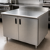 Thumbnail image #3 for Advance Tabco 48 Inch x 30 Inch Enclosed Work Table with Cabinet Base, 14 Gauge 304 Stainless Steel Top, 5 Inch Backsplash, Mid-Shelf and Hinged Doors