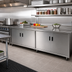 Thumbnail image #2 for Advance Tabco Enclosed Work Table with Cabinet Base, Mid-Shelf and Hinged Doors, 108 x 36 Inches, 14 Gauge 304 Stainless Steel Flat Top