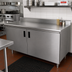 Thumbnail image #2 for Advance Tabco Special Value Economy Enclosed Work Table with Sliding Doors, 108W x 24D, 16 Gauge 304 Stainless Steel Top, 5-Inch Backsplash