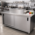 Thumbnail image #2 for Advance Tabco 108-Inch x 36-Inch Enclosed Stainless Steel Work Table with Cabinet Base, Sliding Doors, Mid-Shelf, and 5-Inch Backsplash